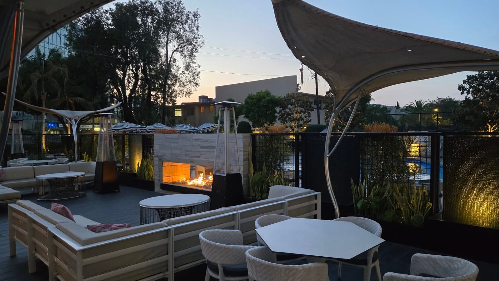 Outdoor terrace fireplace lounge glowing at dusk