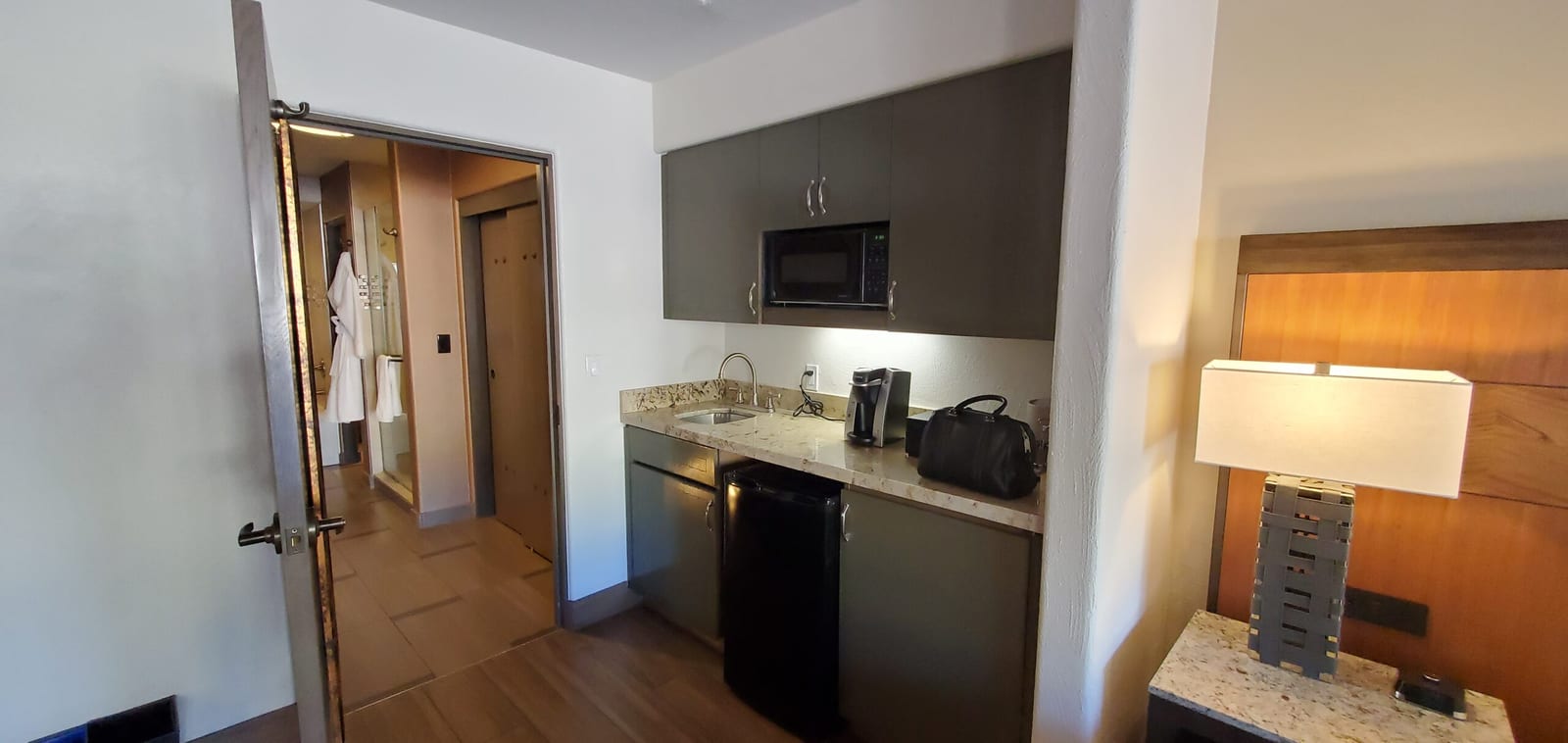Dedicated kitchenette wet bar equipped with granite counters, sink, microwave, and mini-refrigerator. Kitchenette wet bar counter with microwave, sink, and mini fridge