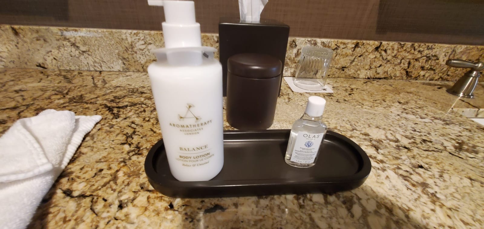 Granite vanity tray with Aromatherapy Associates body lotion and OLAS mouthwash. Vanity counter amenities tray with body lotion and OLAS mouthwash