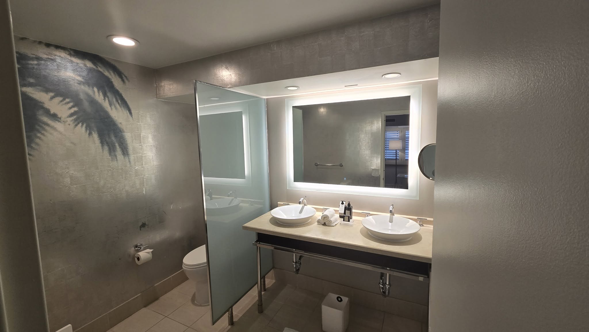 Floating double vanity with twin vessel sinks and circular backlit LED halo mirror